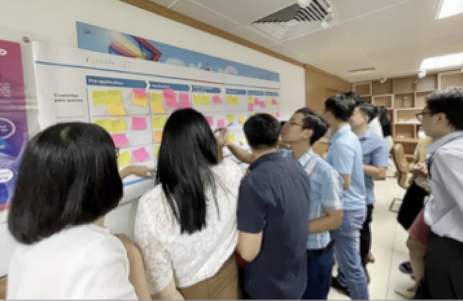 Workshop participants clustering sticky notes on a wall