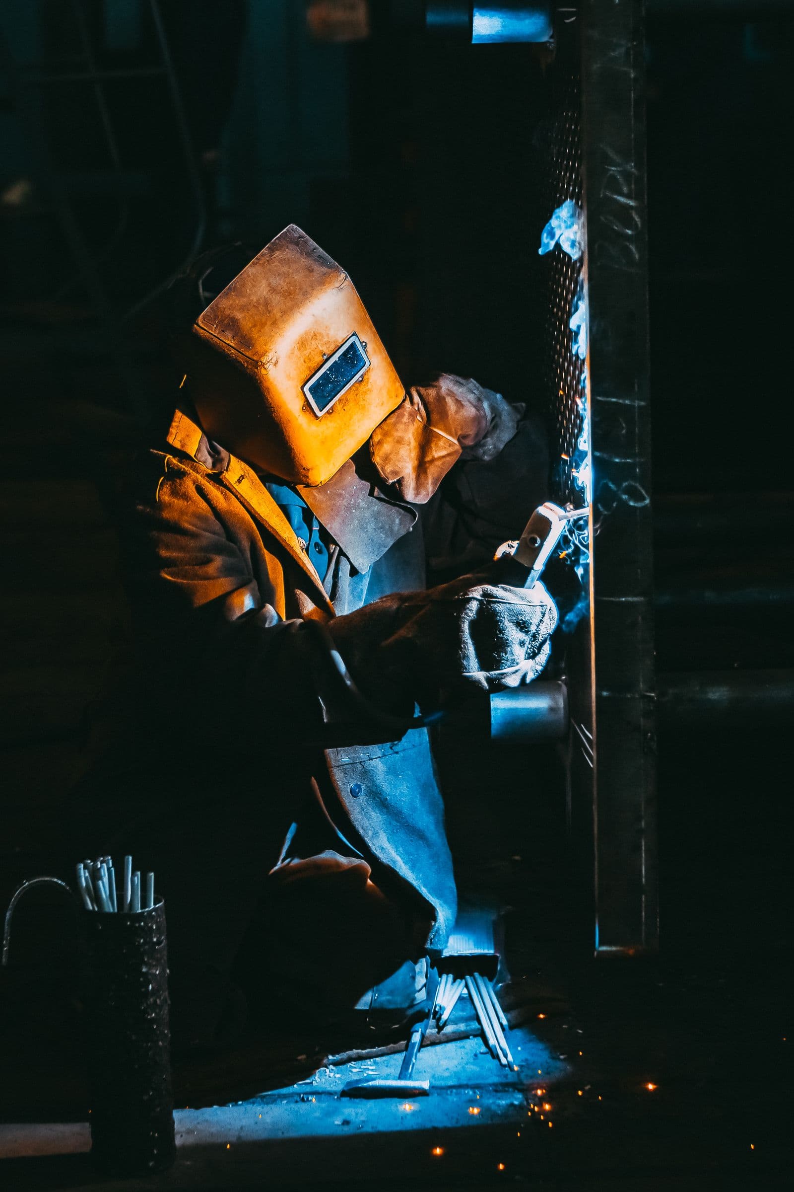 Welder at work in a dimly lit industrial yard