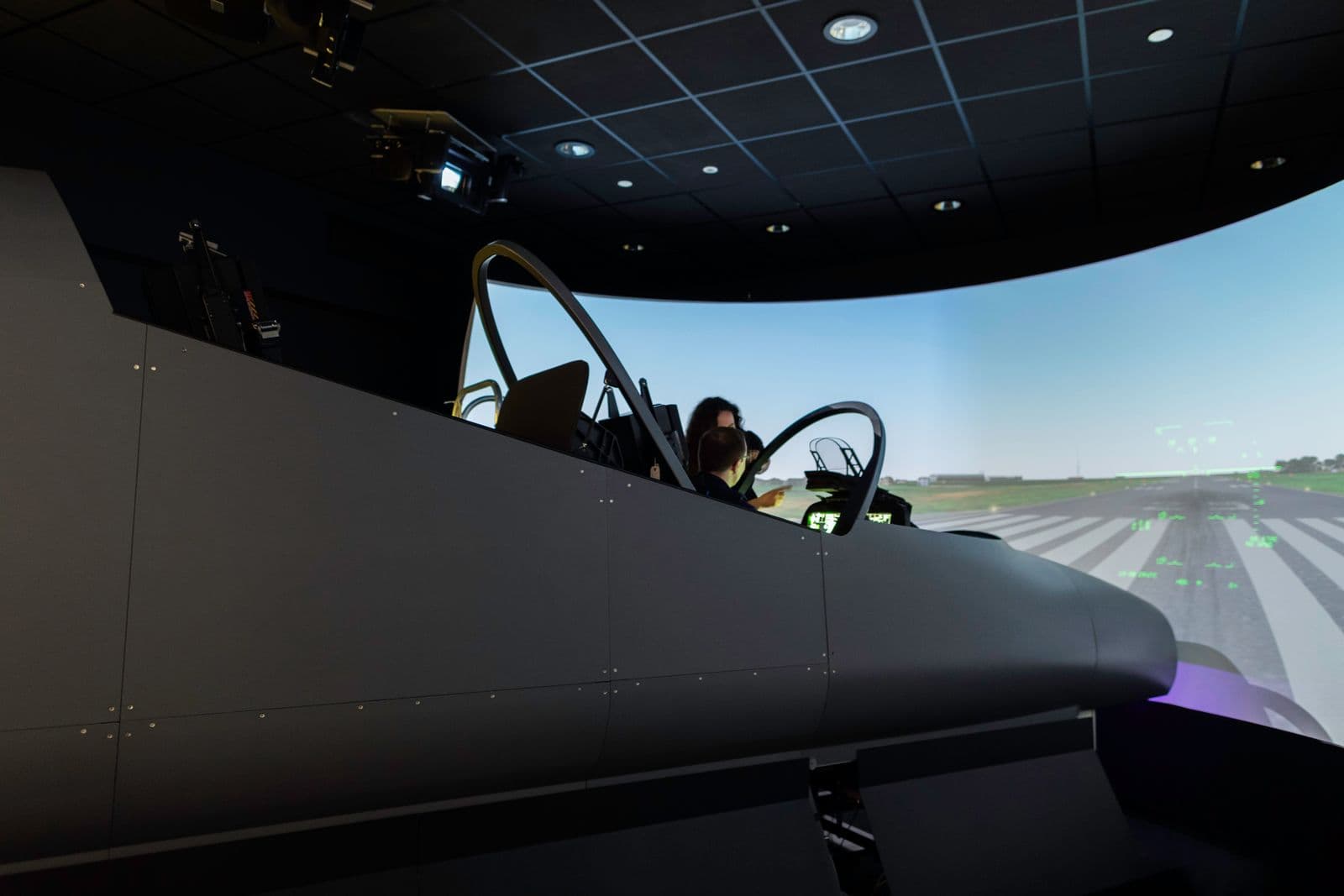 A pilot operating a flight simulator in a training facility